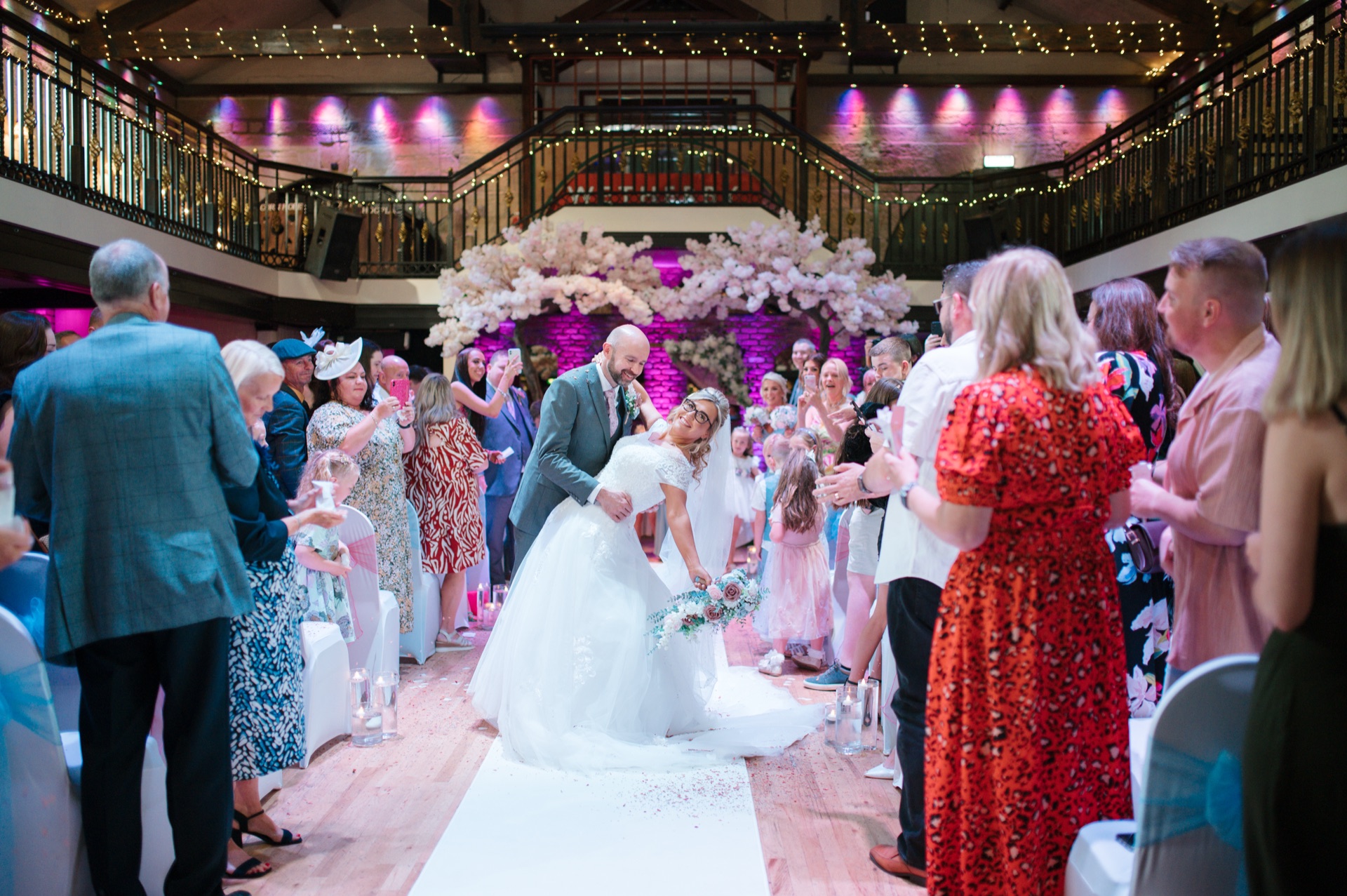 A bride and groom walking back down the aisle between their guests