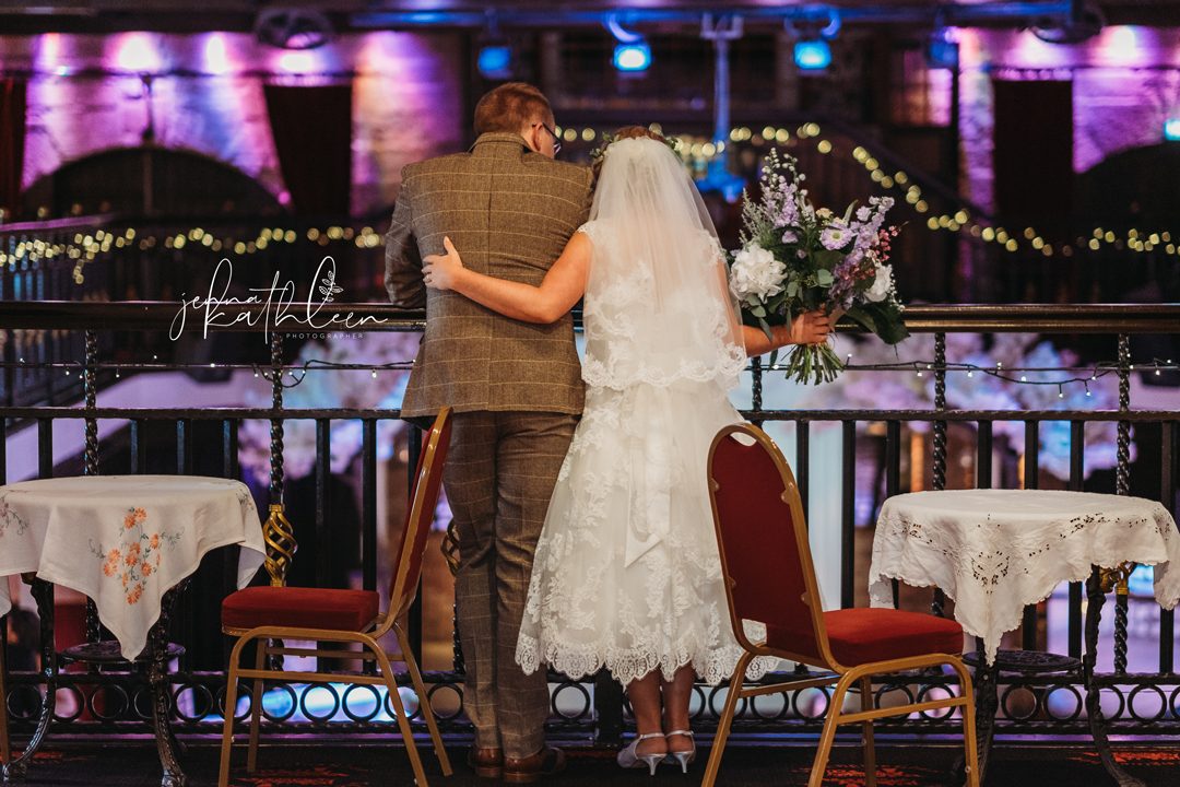 A couple looking out over the room from the mezzanine rail