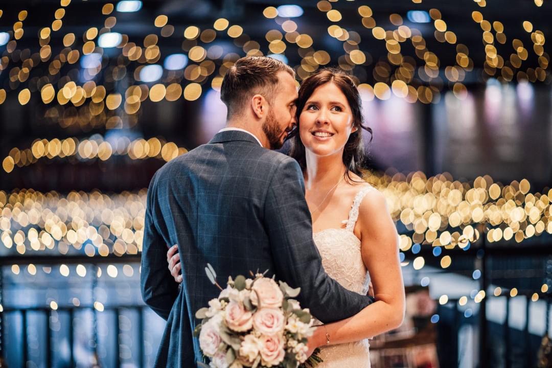 A couple together under the festoon lights at the end of the night