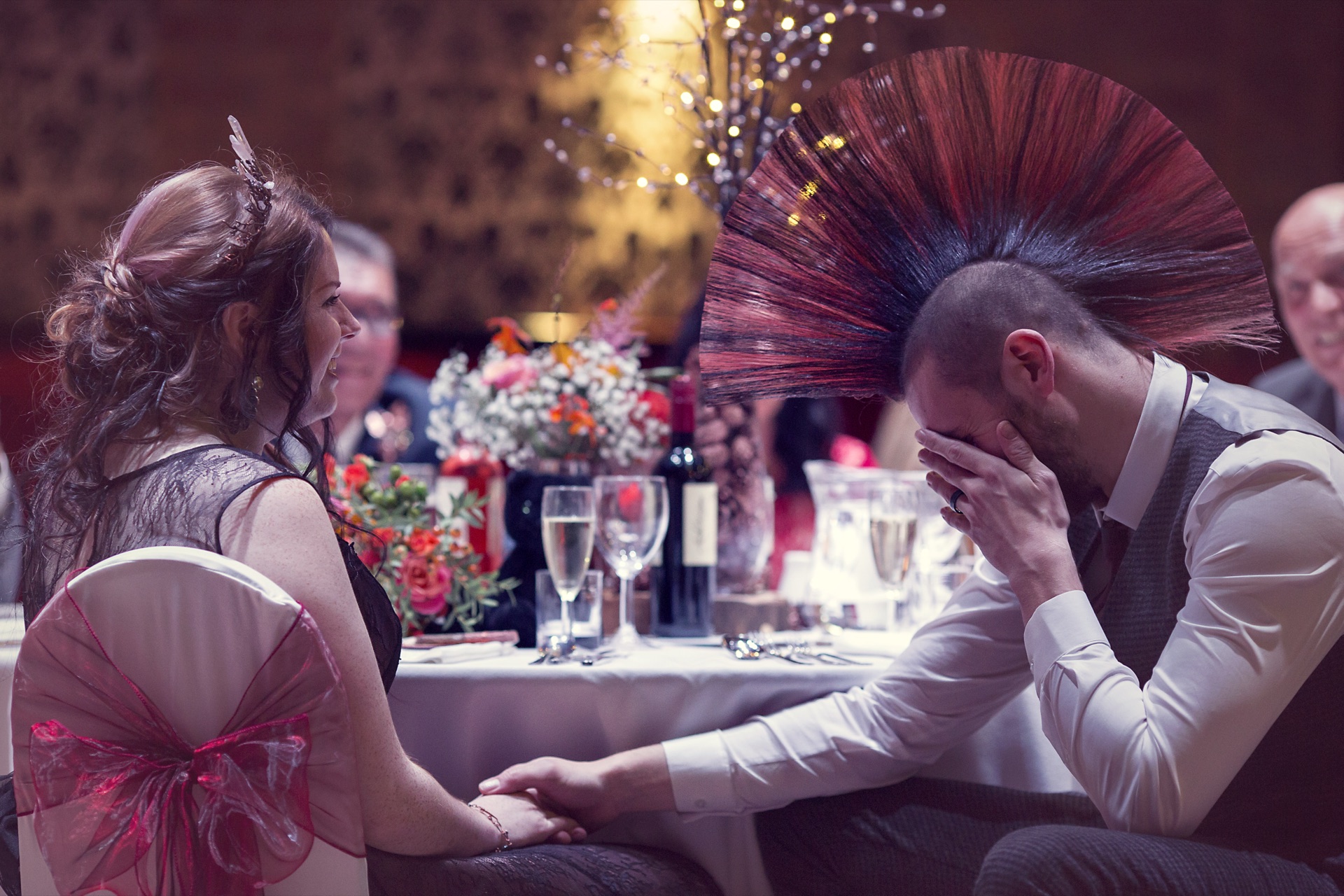 A couple sharing a laugh at their table during the wedding breakfast