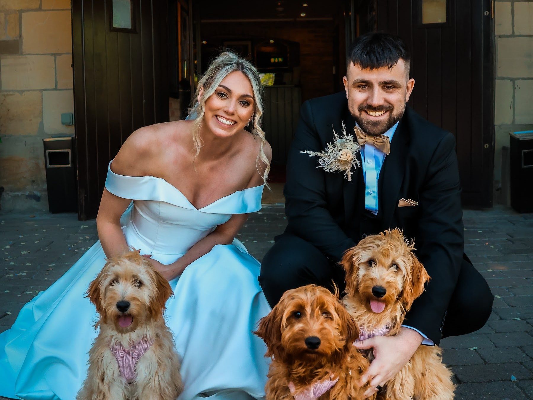 A couple in the doorway of the venue with their three dogs