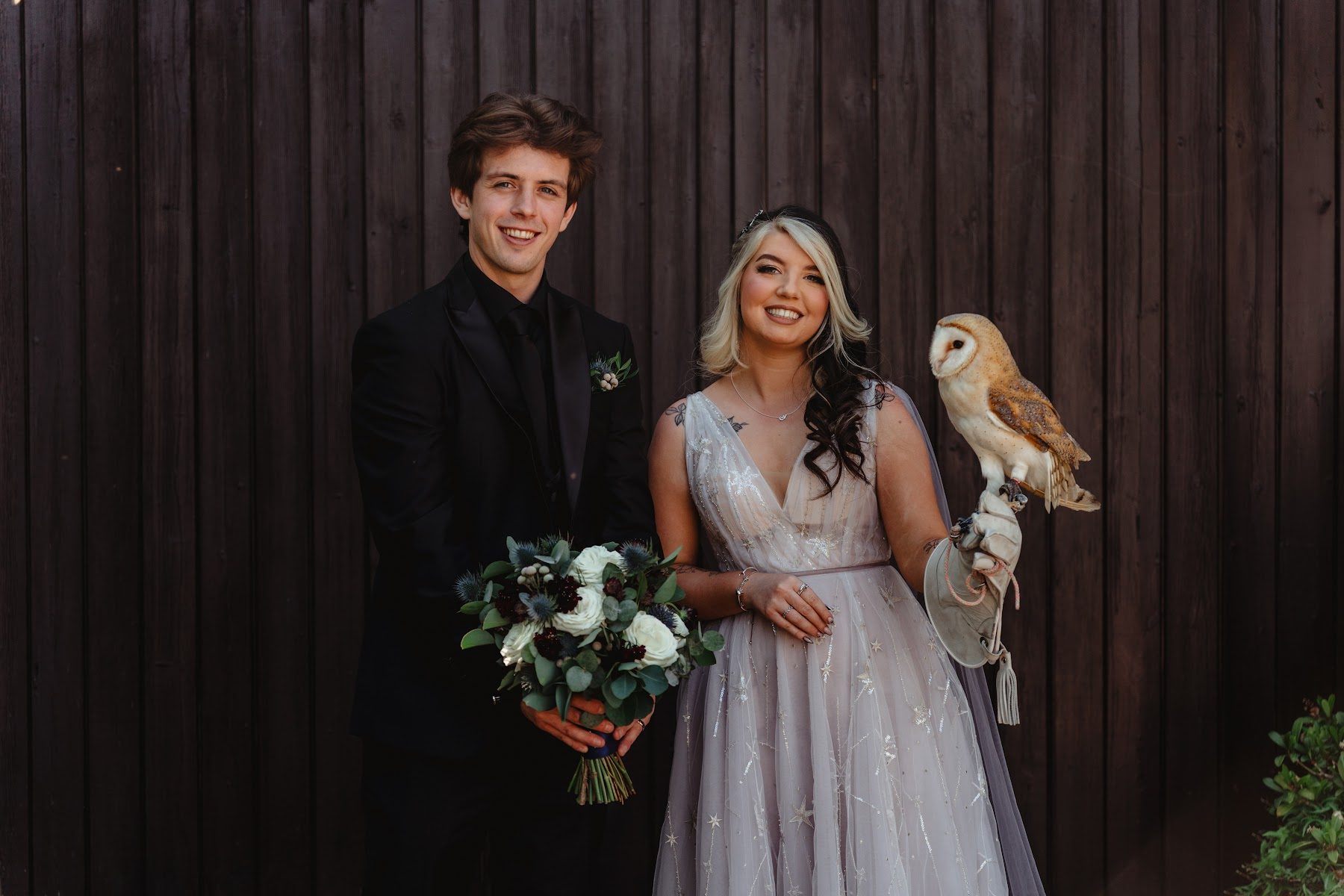 A couple with a barn owl perched on the bride’s hand
