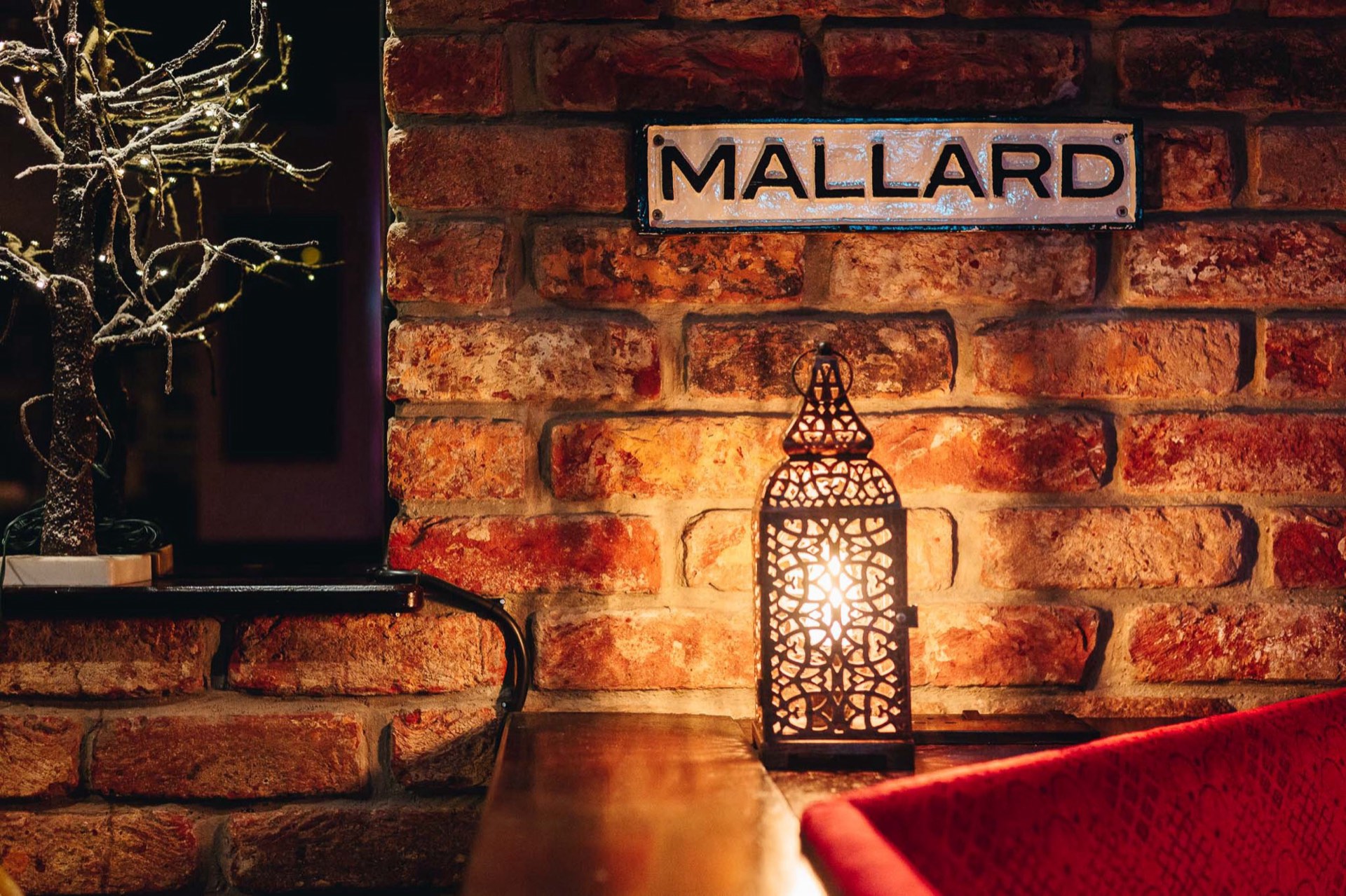 A Mallard railway nameplate and lantern on the brick wall