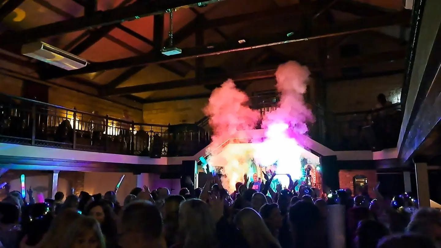 A packed dance floor under the mezzanine as the CO2 cannons fire