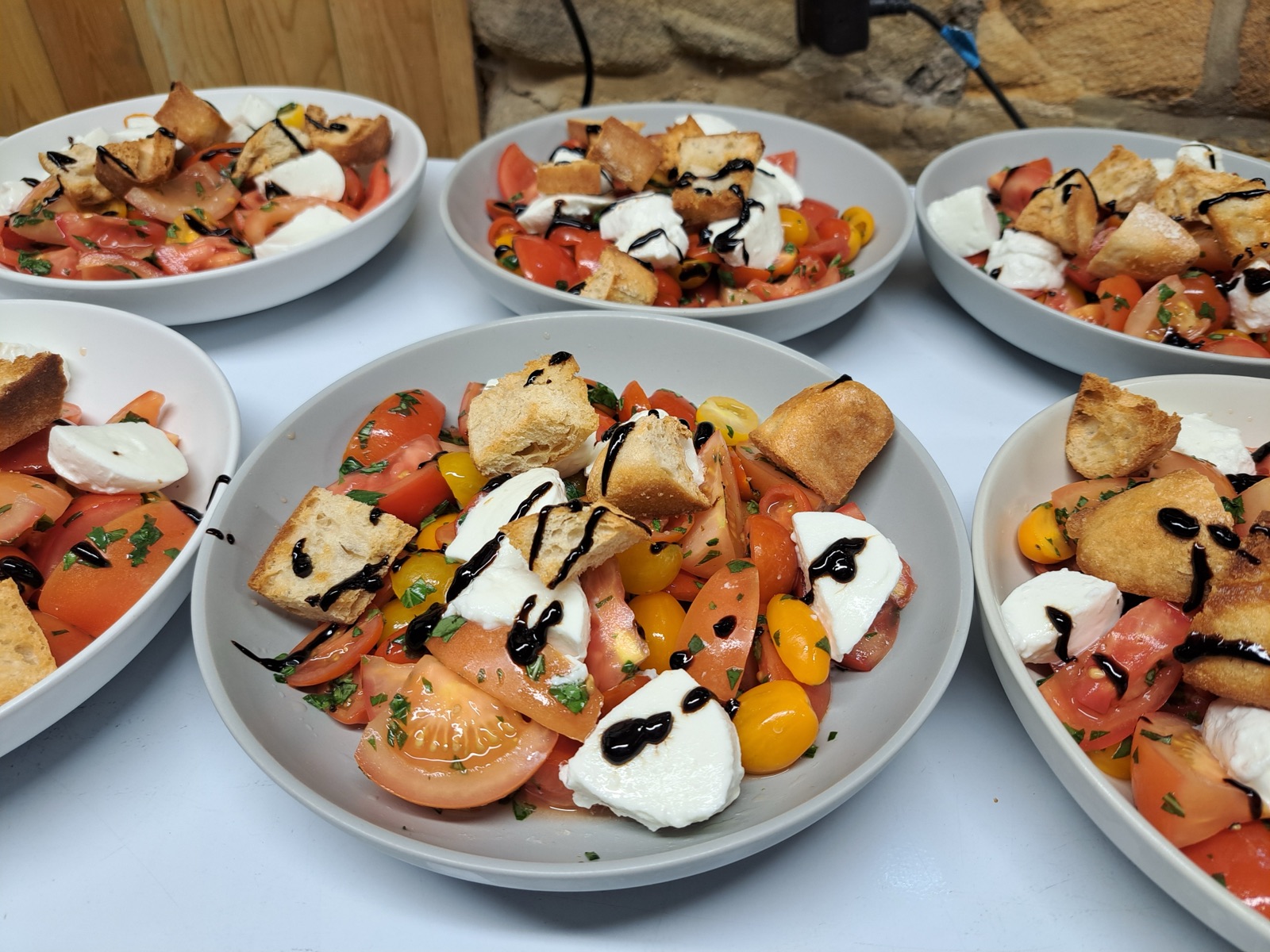 Caprese salad plates dressed with balsamic, plated for a wedding