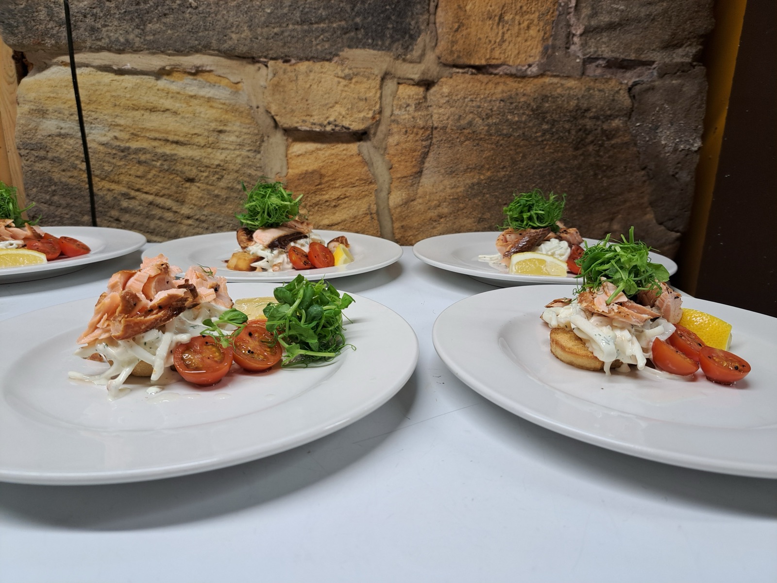 Smoked salmon starters plated against the venue’s stone wall