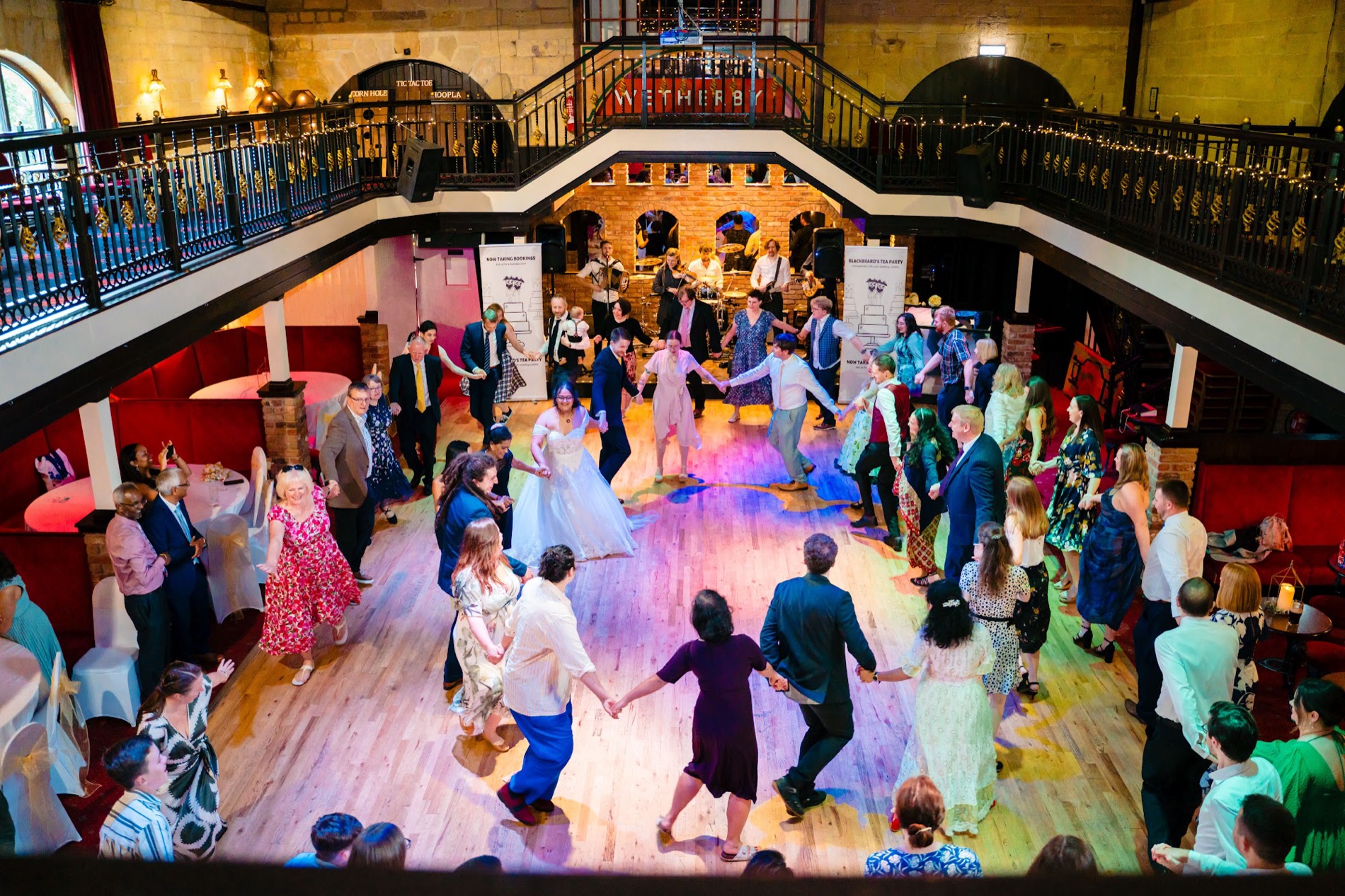 Guests packed onto the dance floor for a ceilidh, the band playing and the mezzanine games above