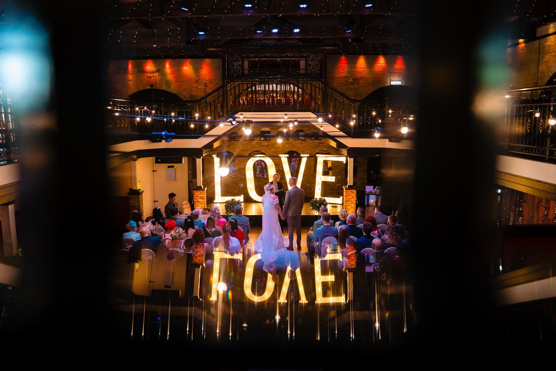Illuminated LOVE letters glowing above the guests at night