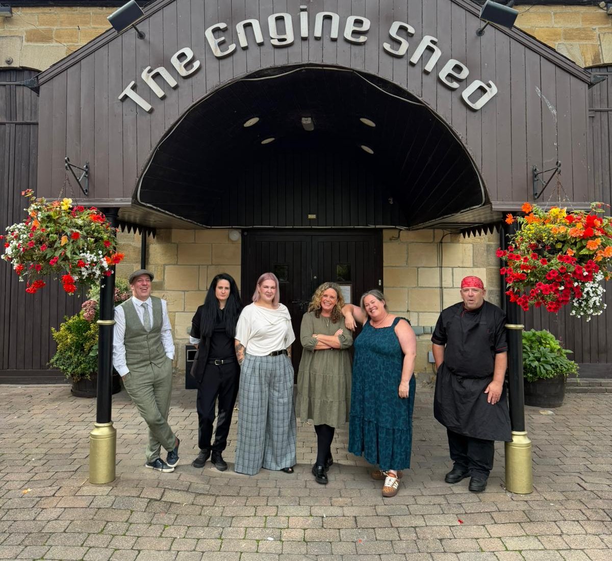 The Engine Shed management team outside the venue beneath the arched entrance